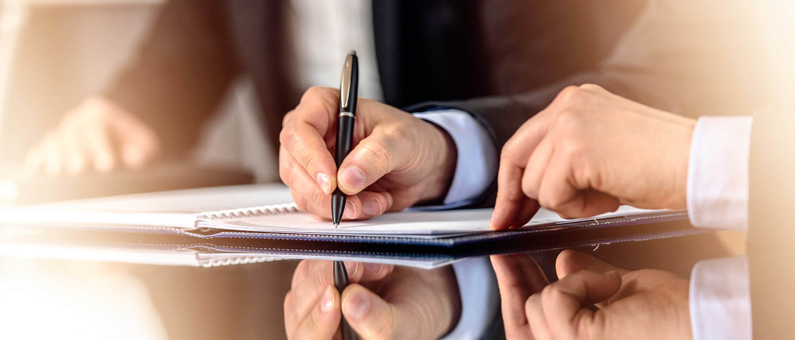 Image of a man writing in a notebook.